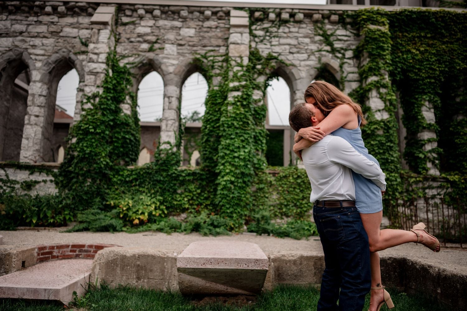 Couple embracing among ivy covered stone ruins